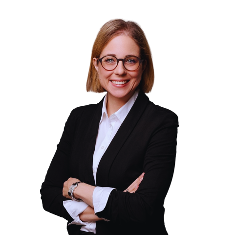 Smiling professional with short hair and glasses, arms crossed, wearing a black blazer and white shirt